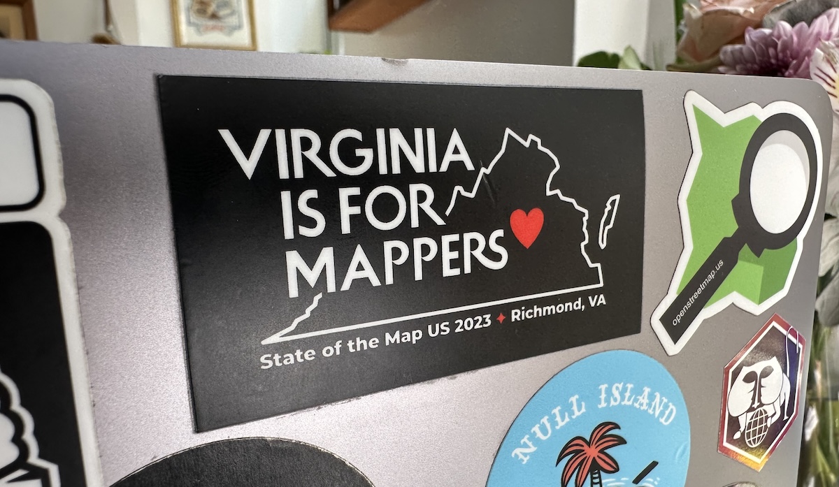 "Virginia is for Mappers" sticker on MacBook along with other OpenStreetMap-related stickers.